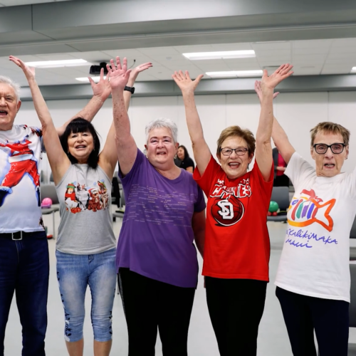 Group of happy people throwing up their arms